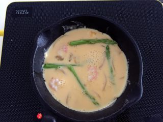6、芦笋虾仁蛋饼—口感松软,补充丰富的蛋白质,稍稍晃动锅子,令蛋液均匀铺满,可以用筷子把芦笋和虾仁调整下位置,移到蛋液表面。