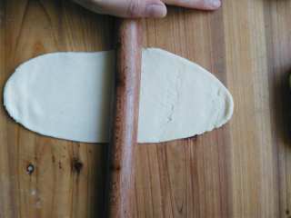 7、健康无糖版的小土司面包,我把面团平均分成六分，然后如图擀开，擀成牛舌状。（如果是450g的土司摸，可以把面团平均分成三份）