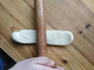 9、健康无糖版的小土司面包,再次擀开卷起来，在这一步一定要把面团卷紧。如果没有卷紧，发酵的时候面团可能会东倒西歪。