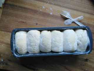 10、健康无糖版的小土司面包,把卷起来的面团最后的部分朝下放，光滑的面朝上放。放进发酵箱里面发酵一个小时左右，发酵到两倍大即可。