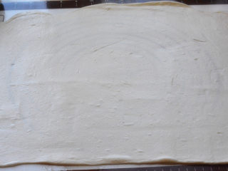 4、油酥肉火烧,在案板上抹上一层油，把发酵好的面团放在案板上，擀成长方成