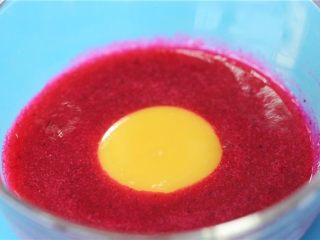 3、这绝不是天边的红日，是宝宝餐桌的美食,取120克火龙果汁，加入一个蛋黄，搅拌均匀