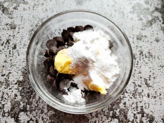 1、巧克力流心汤圆,巧克力放入碗中，加入软化的黄油和糖粉。