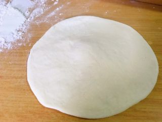 13、红糖伍仁馅糖三角,取一个面球，擀成中间厚四周略薄的小饼。