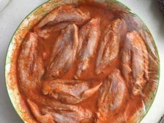 2、新奥尔良烤翅（烤箱版）,如图，把调料和水按1:3比例调和。再把鸡中翅均匀的浸入调料中。放冰箱冷藏室冷藏半天。