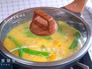 2、虾仁荷兰豆早餐饼,盖上锅盖，小火烘煮。鸡蛋表面凝固即可。