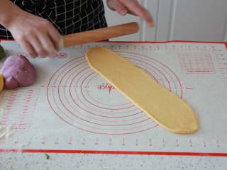 9、蔬菜【四色吐司】,发酵好的面团排气,把面团擀成长条牛舌状,自上而下卷起