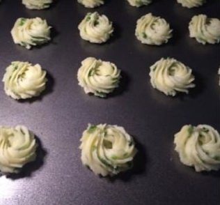 8、香葱曲奇,用小号菊花嘴挤出大小一致的花纹，入预热好的烤箱烘烤至表面金黄，出炉后立即放在晾网上晾凉密封