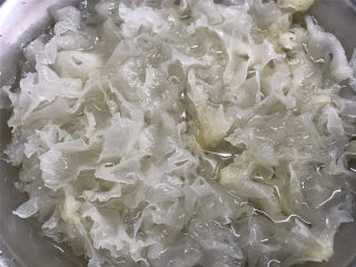 1、蔓越莓桃胶银耳羹,准备好材料，银耳用冷水泡发开。