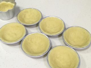 12、港式蛋挞,放入蛋挞模具中，用大拇指按压至完全贴合模具的薄片状。