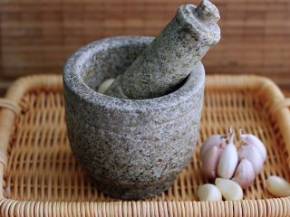 8、记忆中的角瓜鸡蛋饼,把大蒜去皮后、用蒜碾子碾成泥状后、倒入味极鲜和芝麻油调味即可；