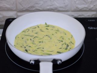 9、记忆中的角瓜鸡蛋饼,接上电陶炉的电源，把平底锅（小白锅）放入电陶炉上，用硅胶刷子蘸少许花生油刷匀平底锅的锅底后，烧至6成热时，把搅拌好的角瓜丝面糊，用勺子舀一勺均匀倒在平底锅里，记住角瓜面糊不要舀的太多哟，舀的多烙出来的角瓜饼会很厚，不好吃的哟；