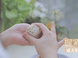 13、春の饭团的2+1种有爱做法「厨娘物语」,取30g米饭握紧成一个小正方形，放上1块煎好的午餐肉，包入海苔片。