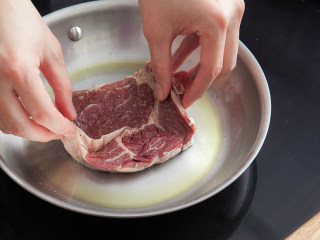 5、橄榄油煎牛排,待油微微起烟后放入牛排，边煎边按压脂肪部位