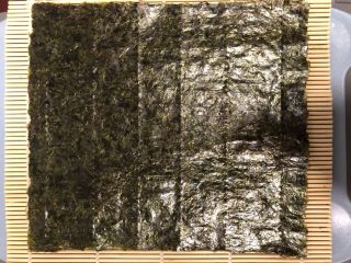 3、简单寿司,铺好竹帘,上面摆一张海苔。