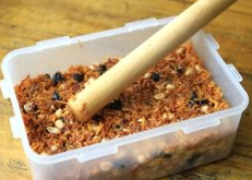 11、苕丝糖,倒入容器中，我用的是塑料饭盒可以不用抹油，如果是其他，可能需要往容器内壁上涂上一层油以免不好脱模。用擀面棒轻轻的敲压表面，不要太用紧,轻轻压一下再整平就好了