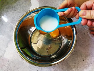 4、蒸着吃的双色甜甜圈米糕 好吃不上火,牛奶倒入蛋黄后放在一边备用（防止蛋黄表皮被风干）