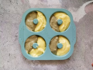 15、蒸着吃的双色甜甜圈米糕 好吃不上火,两种面糊用勺子对半舀进模具8分满，轻震模具震出大气泡