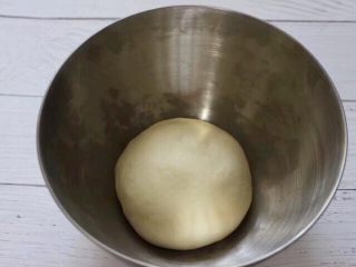 3、圣诞雪花豆沙包,用手揉好面团后，放入器皿里进行一发。