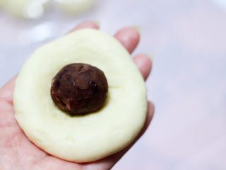 7、圣诞雪花豆沙包,放入适量的豆沙馅料，把边边收口捏紧就可以了。