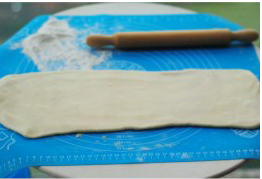 8、可颂,再将面团顺折的方向擀长。