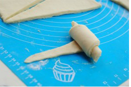 14、可颂,将三角形面片从宽处的底边自上而下卷成牛角形。