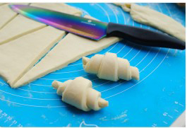 15、可颂,依次卷好所有的面包胚。（多余的切边随意卷起来一起烤烤吧）