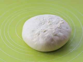 6、酸奶小吐司,将面团倒扣在揉面垫上