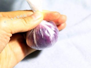 5、紫薯饭团 ,然后抓起保鲜膜的四周，将保鲜膜收口并纽紧，留下点痕迹比较好看。