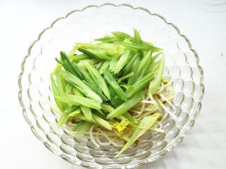 4、水煮肉片,煮好的芹菜和黄豆芽捞出来,铺在容器底部待用。