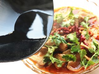 12、水煮肉片,炒锅烧热花生油,泼在花椒和辣椒上面,加香菜点缀,麻辣鲜香的水煮肉片就做好了。