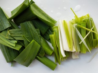 5、飘香蒜苗炒腊兔腿,把白色和绿色部分分开切寸断。