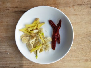 6、飘香蒜苗炒腊兔腿,准备两个干辣椒,姜丝和蒜末。