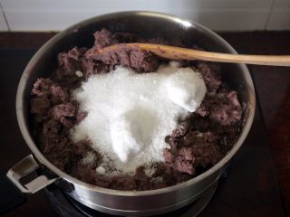 6、50克广式红豆蓉月饼,将搅打过的红豆泥倒入锅，然后加入250克木糖醇，1汤匙的柠檬汁，中火翻炒。