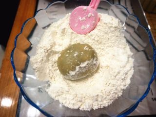 14、50克广式红豆蓉月饼,在中筋粉里滚一圈，同时模具也撒上干粉，倒出多余的。