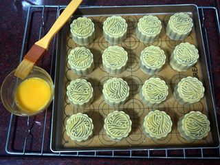 17、50克广式红豆蓉月饼,取出后，刷上一层蛋黄液。然后放入，继续上下火210度烤5分钟。