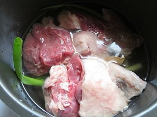 5、羊肉泡馓子,电饭煲内铺上葱段、姜片,放入羊肉和没过羊肉的水,设置羊肉键炖30分钟,不要炖的太烂