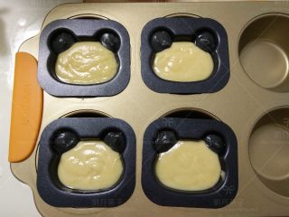 8、小熊棒棒糖蛋糕, 把黑色面糊挤入模具的耳朵部位，其余挤入原色面糊。