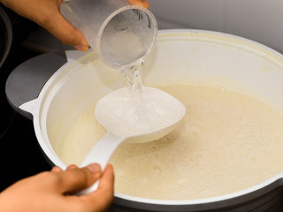 12、不用盐卤，不用内脂，一样做出好吃的豆腐,等豆浆温度降到差不多70-80度，可以放白醋水，分成3-4次放，每次倒入搅拌一下。这个温度基本上关火后十分钟。或者是用手去喷豆浆，虽然烫手但是也可以触碰，这样温度也差不多的。