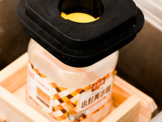 16、不用盐卤，不用内脂，一样做出好吃的豆腐,上面放上重物，不用太重，我这个是个空瓶子，加了个料理机的盖子。压制时间15分钟。压得重量和时间决定豆腐的嫩还是老。