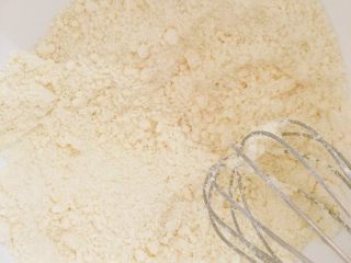 2、超快手的黑芝麻麻薯和蔓越梅麻薯,缓缓加入麻薯预拌粉,慢慢搅拌,使黄油和预拌粉充分混合均匀!