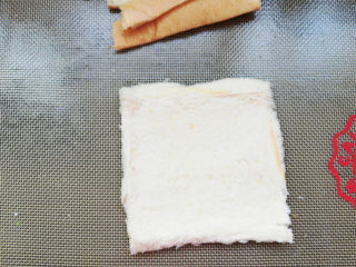 7、香肠紫薯吐司卷,用擀面杖擀扁。