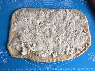 9、南瓜椰蓉面包,取一半馅料均匀的铺在面片上