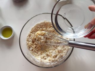 3、芝麻红糖饼 ,加入100g凉开水,一边加一边慢慢搅拌,最后不会出现结块