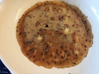 9、芝麻红糖饼 ,将1/4左右面糊倒入,倒入后马上转动平底锅,让面糊自动形成圆形(和煎可丽饼一样哈),中火煎,当糖饼基本凝固,边缘有点焦脆的感觉(如图),即可