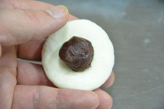 4、小兔包子,将小块面团揉匀压扁，包入豆沙馅