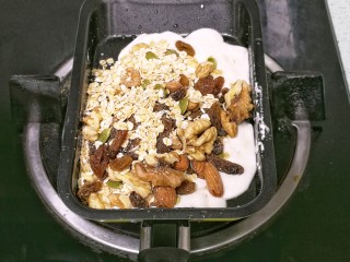 7、果仁燕麦能量棒,倒入果仁燕麦混合物，用铲子翻拌均匀。