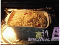 6、黄金海鲜焗饭,烤箱预热，将炒饭放进烤箱里，以180度焗烤15分钟，烤至表面金黄色即可