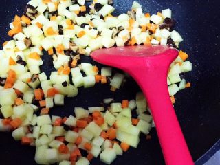 8、电饭锅土豆腊肠饭,放入香菇丁,继续翻炒10秒