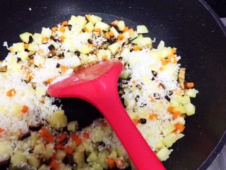 9、电饭锅土豆腊肠饭,倒入沥干水的米,加入10g酱油,5g芝麻油,2g盐,快速翻炒10秒